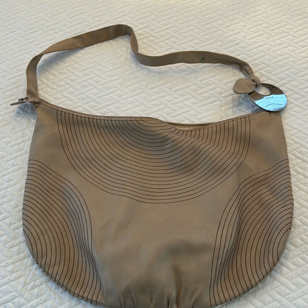 Furla bag in used condition in a cream tan color withh burgundy stitch